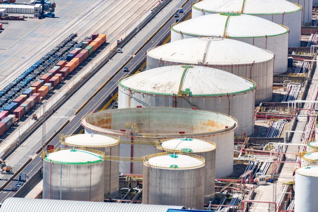 Crafting Captivating Headlines: Your awesome post title goes here Aerial shot of large oil storage tanks in an industrial district with adjacent railway tracks.