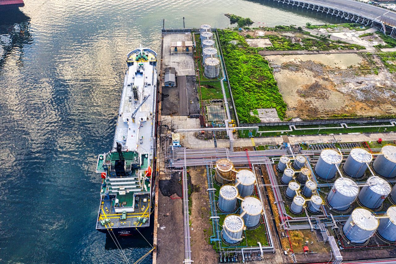 Mastering the First Impression: Your intriguing post title goes here Aerial view of a ship docking at an industrial port with storage tanks in North Jakarta.